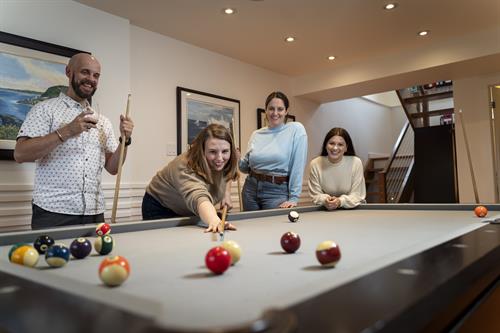 Guests enjoying the games room with a game of pool.