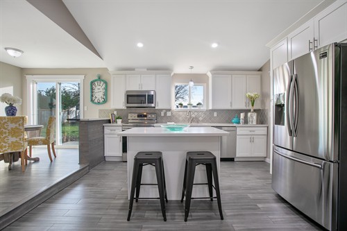 Kitchen remodel with white cabinetry, island seating and an open dining area. Kitchen remodel with white cabinetry, island seating and an open dining area.