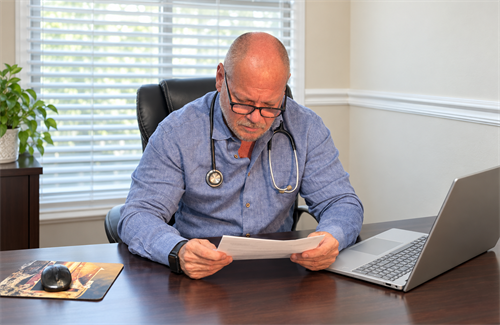Dr Timothy Mackey reading labs in the office at NovaGenix