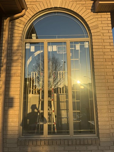 Elegant black front entry door with decorative glass and an arched transom, professionally installed for improved security, insulation and curb appeal.