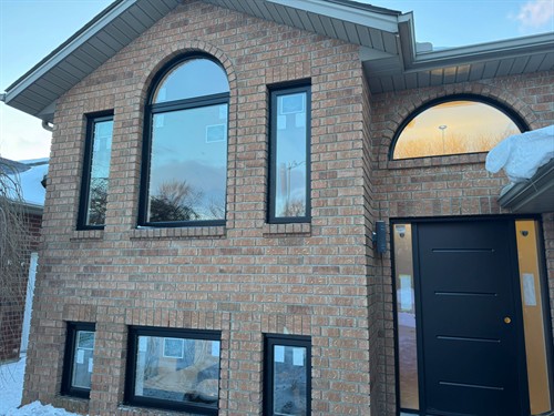Custom black energy-efficient replacement windows installed by EcoTech Windows & Doors, enhancing this Canadian home’s comfort, insulation and modern curb appeal.