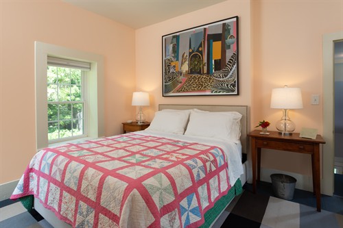 Main bedroom has windows on three sides and original art.