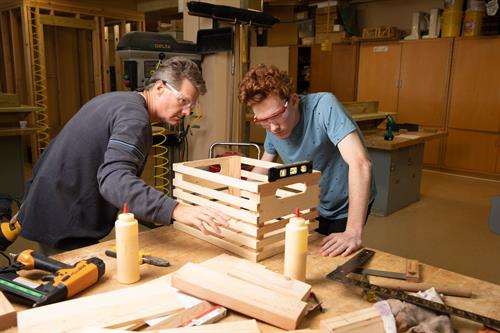 Teacher and student building a box in wood shop class.