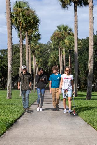 Two blind students and two deaf students walking down Palm Row.