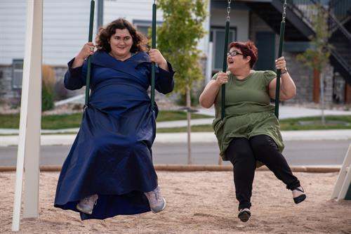 Joyful day at the park as Essential Living Support clients enjoy swings and movement with caring staff in Cheyenne, WY.
