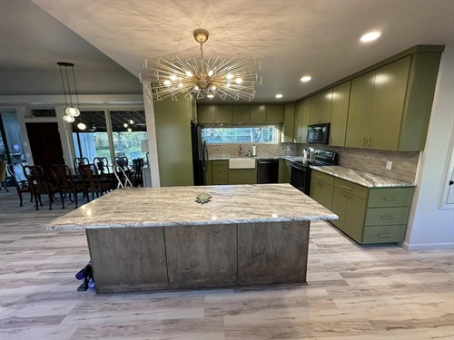 Kitchen remodel including taking down existing walls to open the space to the living room. New cabinets, countertop, backsplash, island, flooring, light fixtures, plumbing fixtures, and paint. 