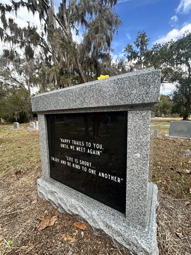 Custom monument featuring a polished granite panel with engraved lettering, designed for a lasting and meaningful tribute.