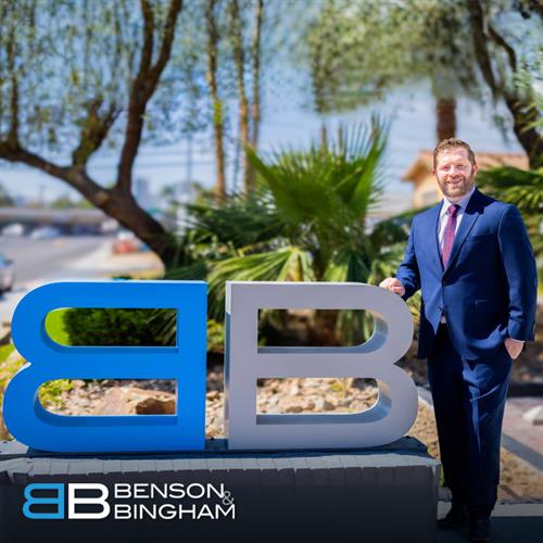Jordan Kingsley, attorney at Benson & Bingham, poses beside the firm’s logo in Las Vegas—representing clients with dedication in personal injury cases.