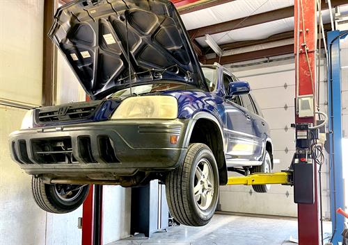 Honda CR-V on one of our vehicle lifts waiting for mechanical repairs. 