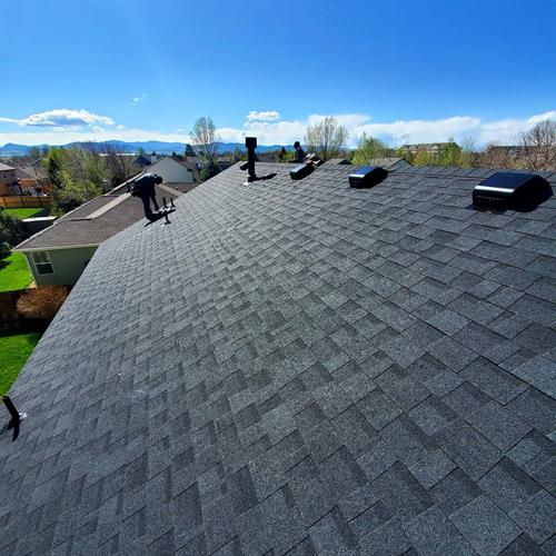 Putting the finishing touches on a newly installed roof. Don't you just love the sleek look of Owens Corning Onxy Black shingles?