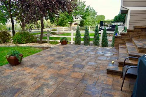 A paver patio installed and planted around by Front Range Landscape LLC