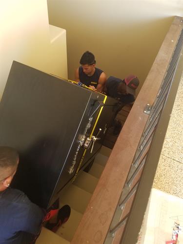 Our hard working crew moving a 400 lbs gun safe into the basement of a new home!