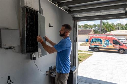 Electrician inspecting residential electric panel after a home rewiring job 