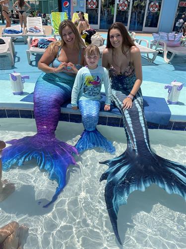 Mermaid Regan and Mermaid Emvi with a little mermaid at Jolly Roger