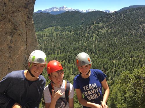 Rock climbers in helmets and rope pose for a photo