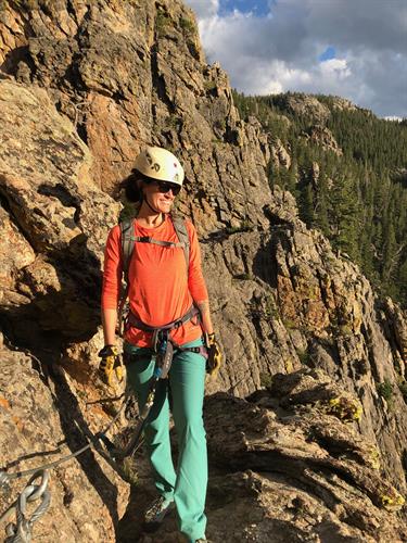 Woman in climbing gear walks on a rock