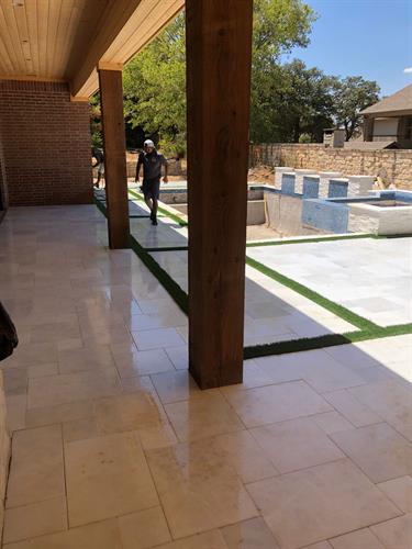 travertine pool decking with synthetic grass stripes