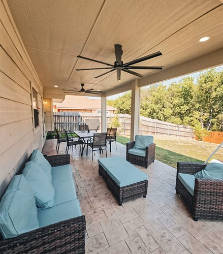 A comfy attached patio cover wrapped in LP smart siding and painted to math the house with a stamp & stained concrete patio underneath.