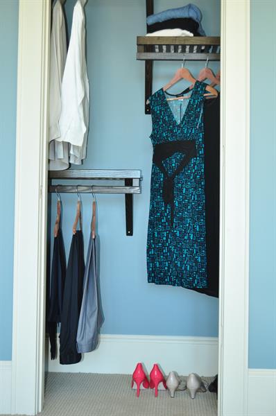 Reach in closet with high and low hanging areas, plus shelves