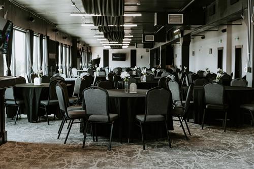 Event center view of tables & chairs with TVs and PA system.