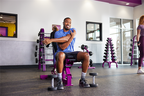 Gallery Image 97.)_Free_Weights_-_Millenial_Male_stretching_at_the_free_weights_(1).png