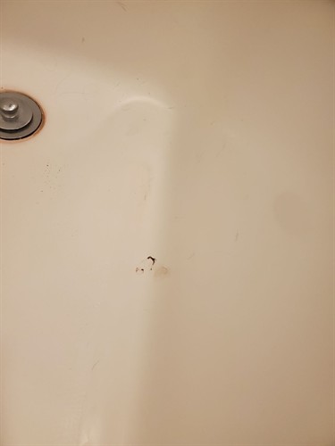 Impact hole on a tub floor.