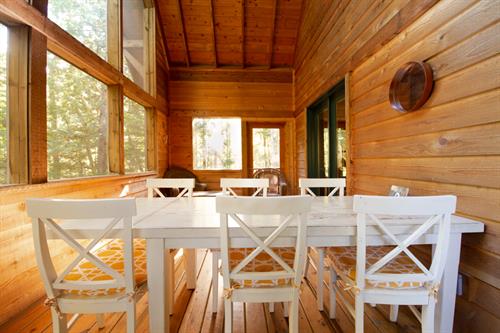 Enjoy the sounds of the forest as you have dinner or play cards on the rustic six-person dining table. Enjoy the sounds of the forest as you have dinner or play cards on the rustic six-person dining table.