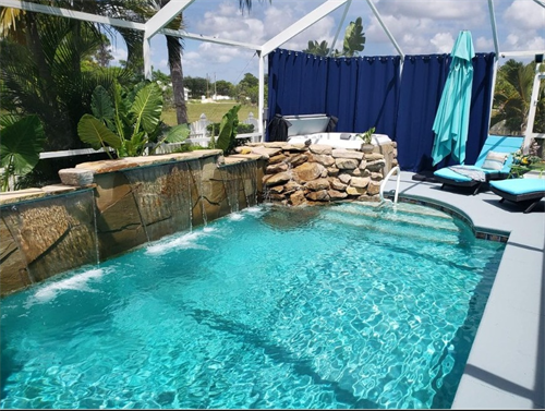 Stone cladding sheer descent pool water feature.