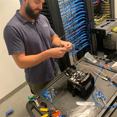 Demarc Telcom tech splcing fiber optic connectors on at Dartmouth College. 