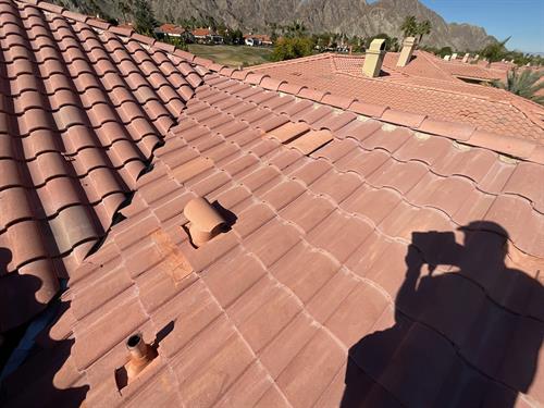 Inspecting a clay tile roof. Looking for cracks and slipped tiles.