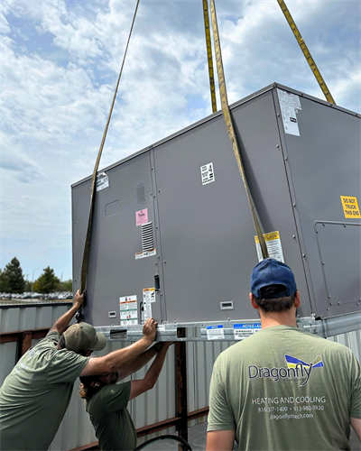 Heavy equipment teamwork. Our crew, in full safety gear, precisely coordinates the installation of a massive rooftop HVAC commercial unit by crane.