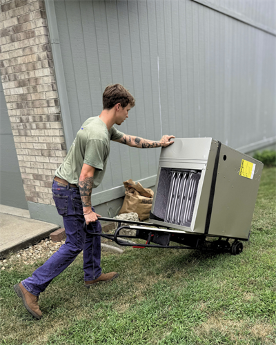 Care and precision. Safely and carefully moving a heavy new furnace unit into position using an ergonomic specialized hand truck on location.