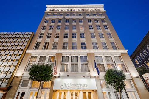 Twilight exterior photograph of the St. Christopher Hotel in New Orleans.