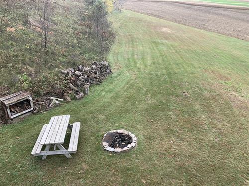 View of the back yard from your balcony, featuring picnic table and fire pit