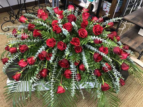 elegant and classic red rose floral tribute casket spray