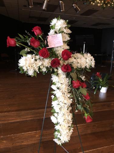White floral cross with elegant red roses; A classic floral tribute
