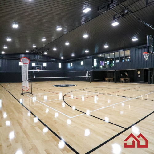 Tucked within this home’s private sports complex lies a court that rivals professional arenas—yet feels distinctly personal. The polished hardwood gleams beneath bright recessed lighting, its smooth grain and crisp black-and-white lines defining space for both basketball and volleyball. 