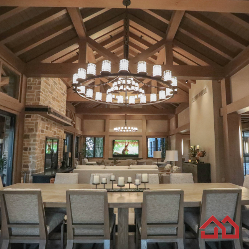 Modern rustic timber framed great room serves as the main level dining room, living room and television viewing area. Beautiful vaulted ceiling with exposed wood beams and paneled ceiling. Heated floors. Two sided stone/woodburning fireplace with a two story chimney and raised hearth. Exposed timbers create a rustic feel. 