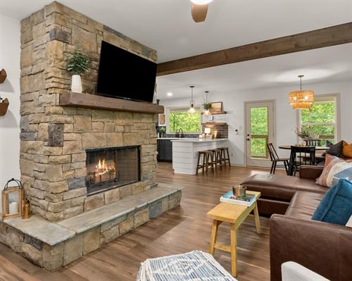 Cozy up in our inviting family room, featuring a wood-burning fireplace, a genuine leather sofa, and an open-concept layout that flows seamlessly into the dining and kitchen areas