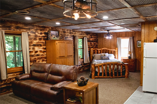 Illinois cabin with rustic charm and modern amenities — full kitchen, comfy bed, and sofa.