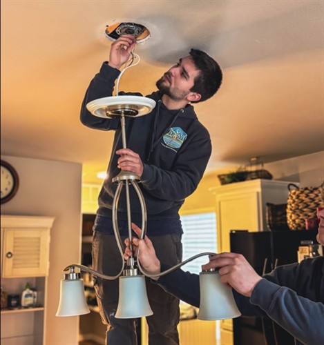 Licensed electrician installing a modern light fixture during a residential electrical upgrade in Mount Vernon, WA.