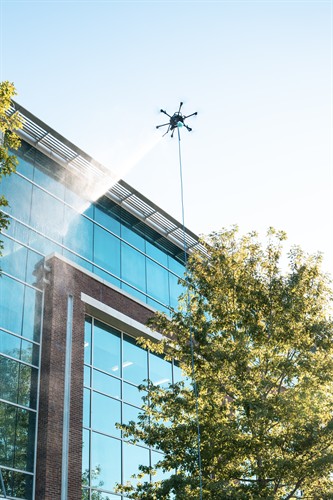 Drone-assisted commercial window cleaning for large and hard-to-access buildings.
