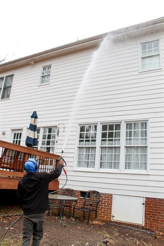 Our technician completing a house wash for one of our clients. This service utilizes a method that involves low-pressure stream and a special mix of chemical solutions to clean your home. This process removes bacteria, mildew, algae, spider webs and other organic strains on your home's exterior.