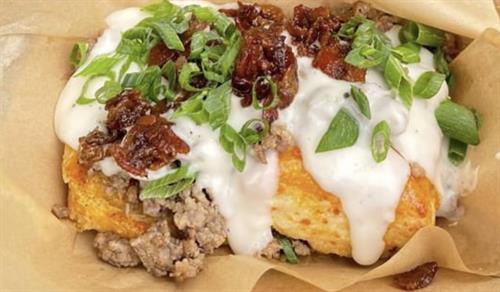 Sourdough biscuit topped with sausage gravy, bacon jam & green onions