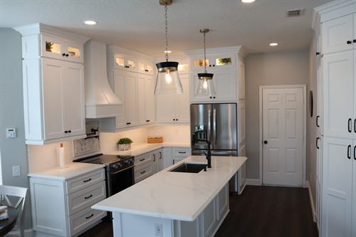 Kitchen renovation with Brooklyn White cabinets, Brescia Calacatta quartz, interior cabinet lighting, undercabinet lighting, and matte black finishes. 