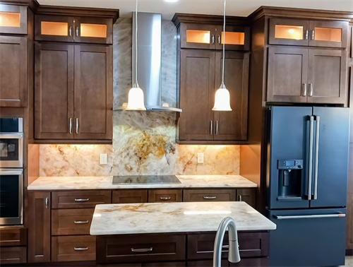 Espresso cabinetry, full-slab quartzite backsplash, and a waterfall island countertop come together in this statement kitchen renovation.