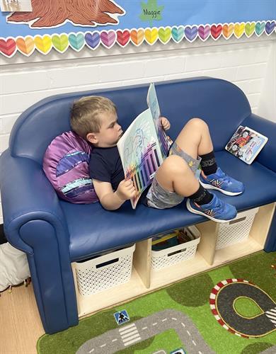 This scholar helps himself to a book so as to read independently.