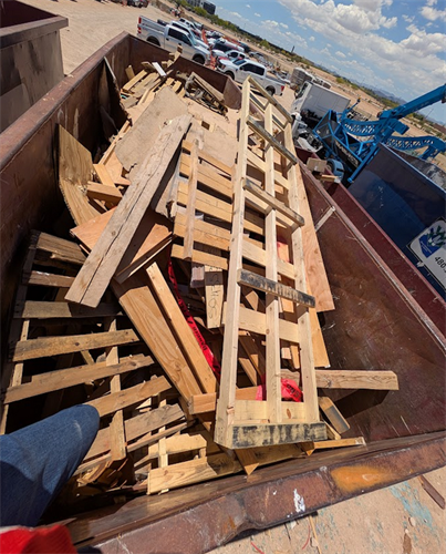 Full dumpster with wood