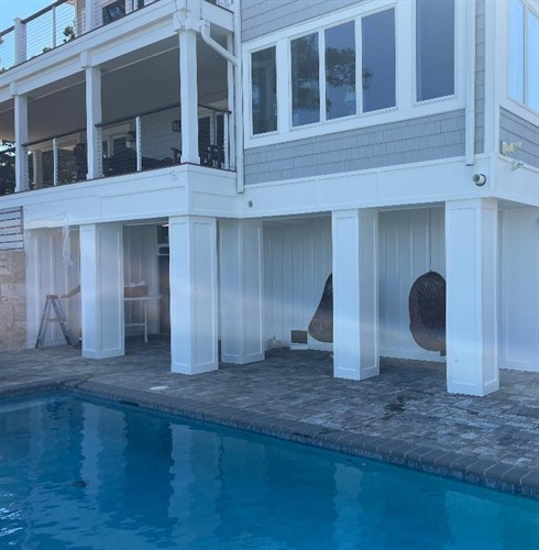 Here we enclosed below the house by the pool and fabricated PVC sleeves for the support posts. A beautiful addition to this home!