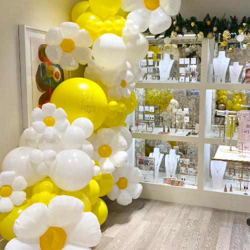 Balloon Garland with Daisies installed at Kendra Scott Eton for Woman Up Cleveland Event